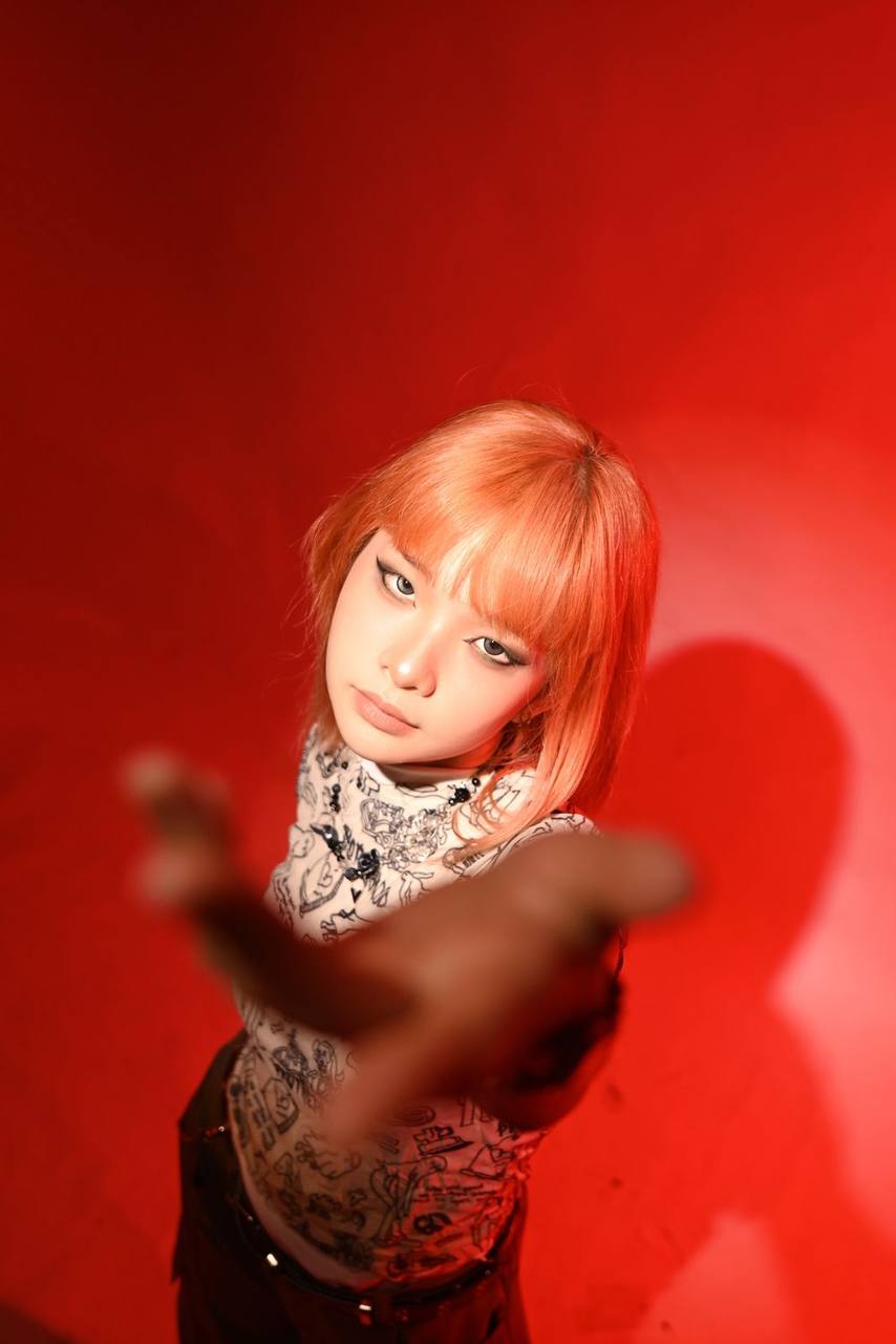 Editorial campaign, red backdrop, reaching toward camera