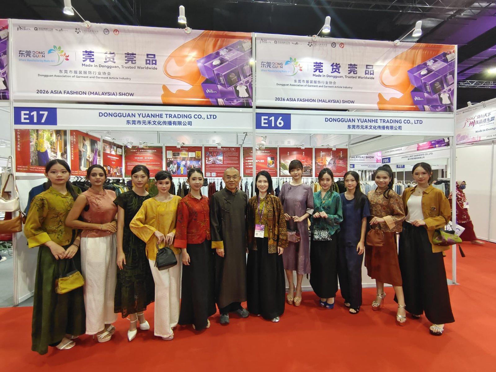 Models with the designer at the exhibition booth