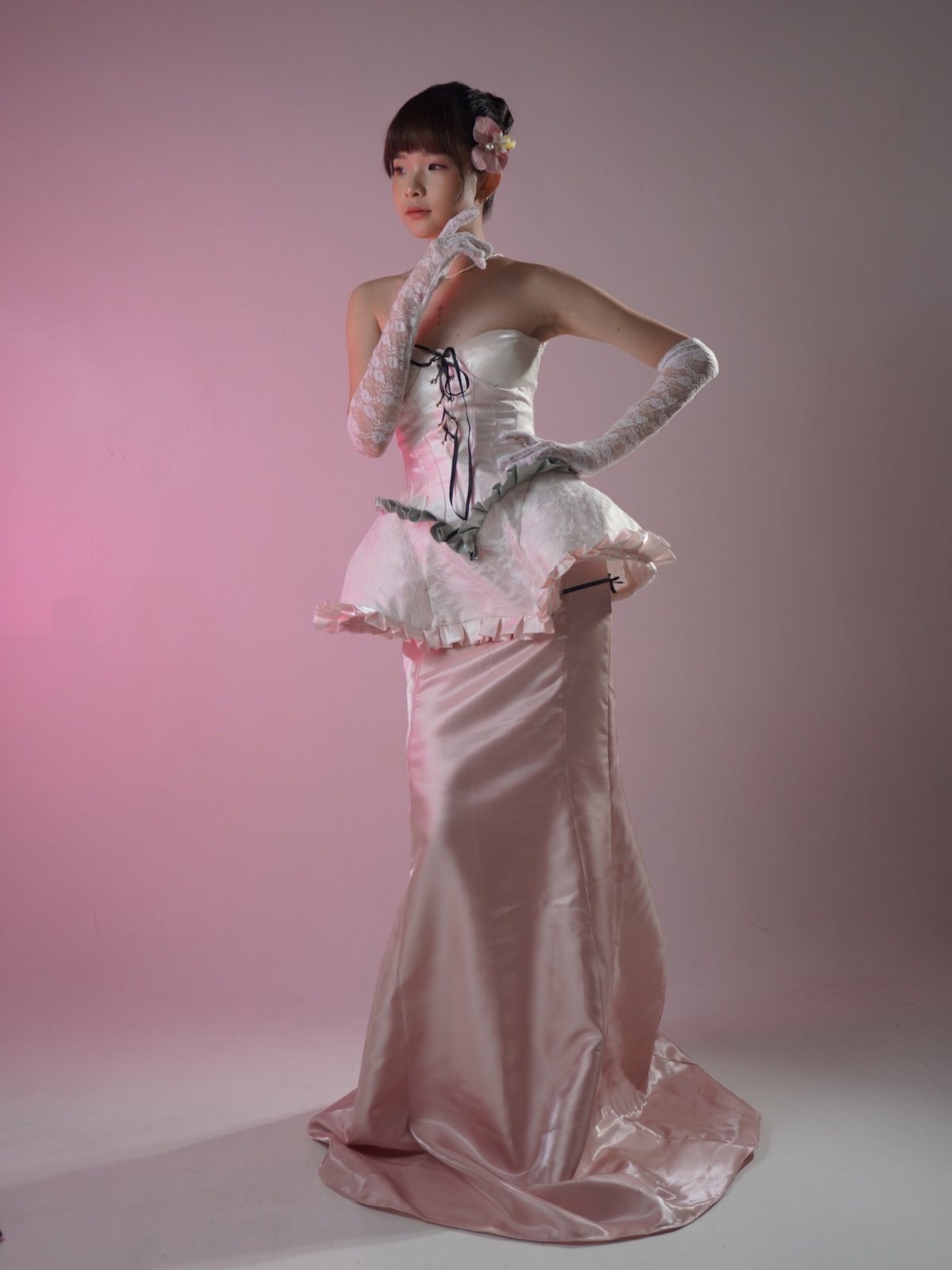 Lace-up corset gown, gloved hand at the chin