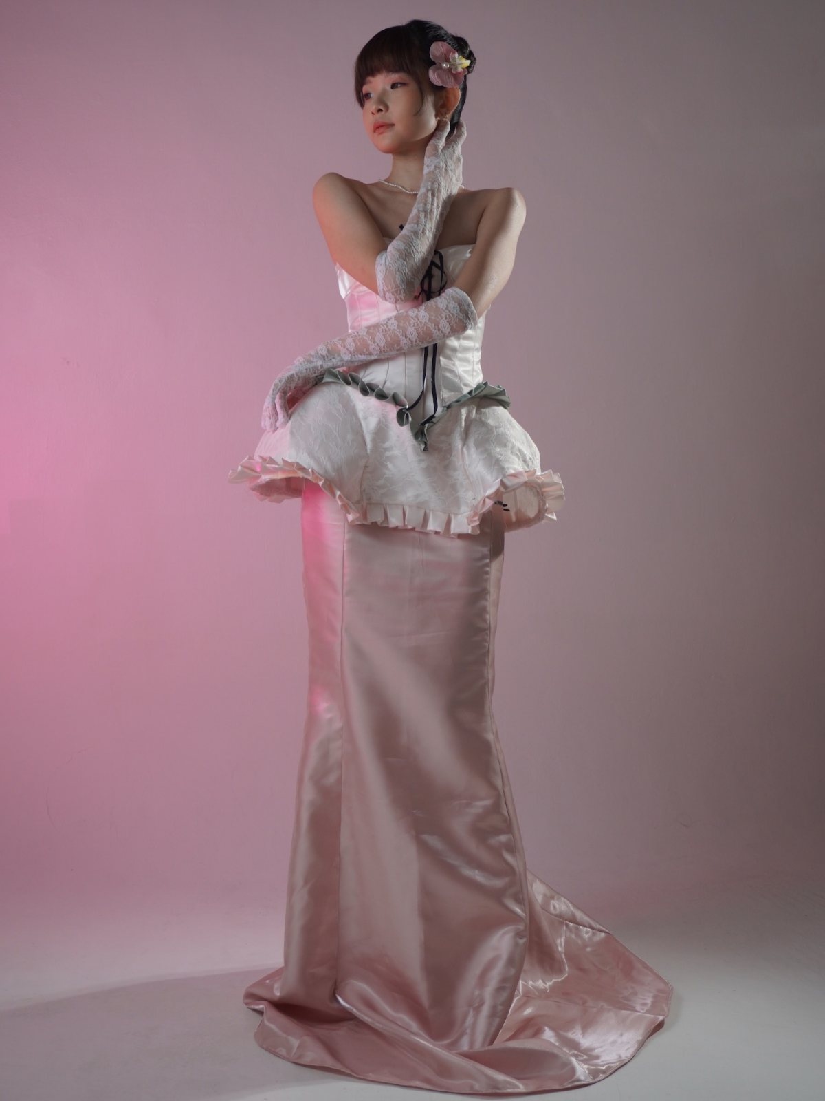 Lace-up corset gown, gloved arms crossed at the shoulder