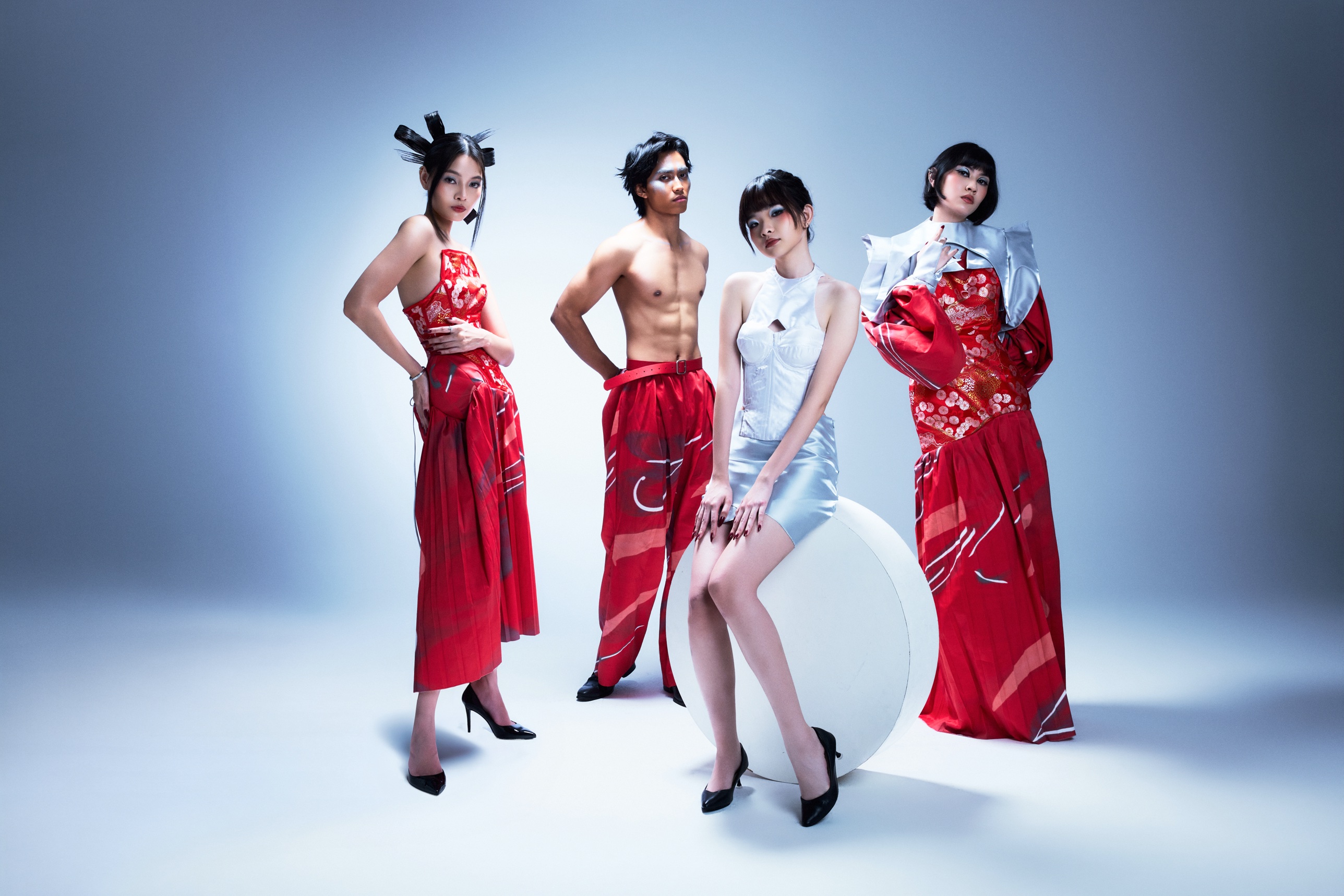 Four looks in red brocade and silver satin on a blue backdrop