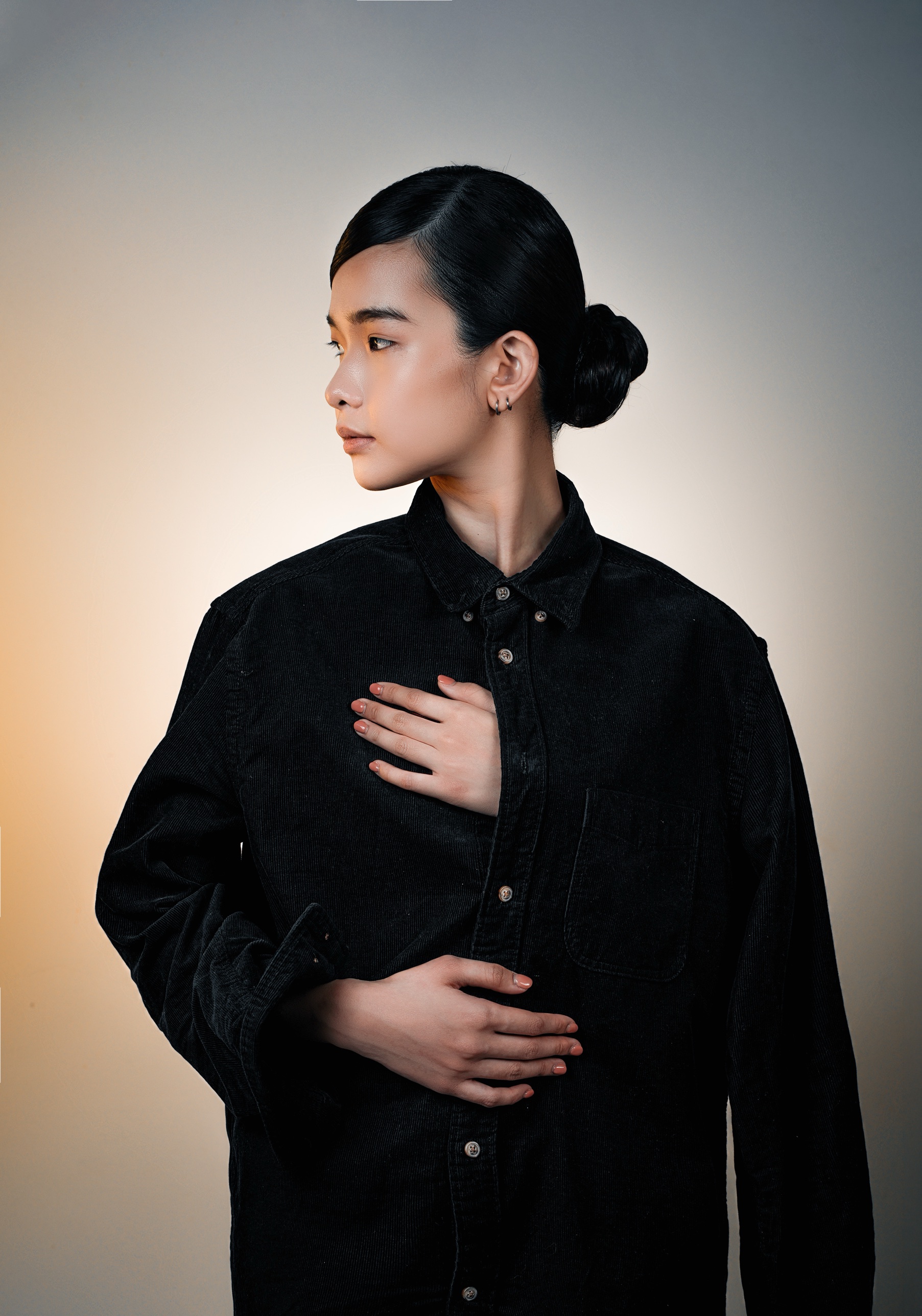 Profile looking left, hands at the chest