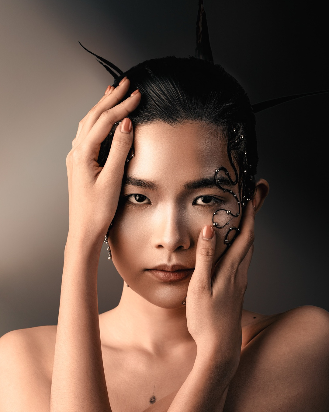 Hands framing the face, beaded hair art