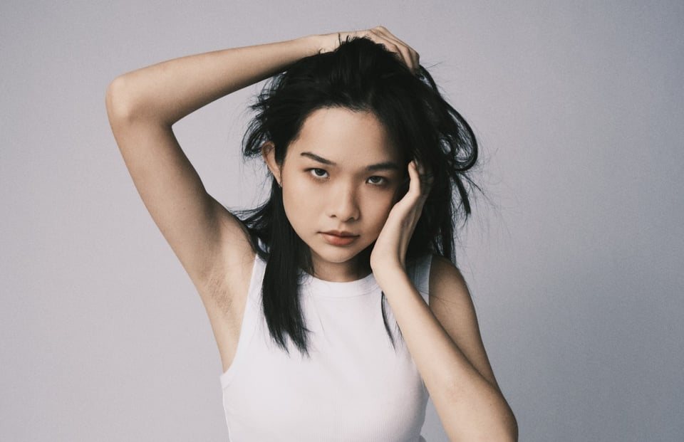 Hand in hair, looking to camera