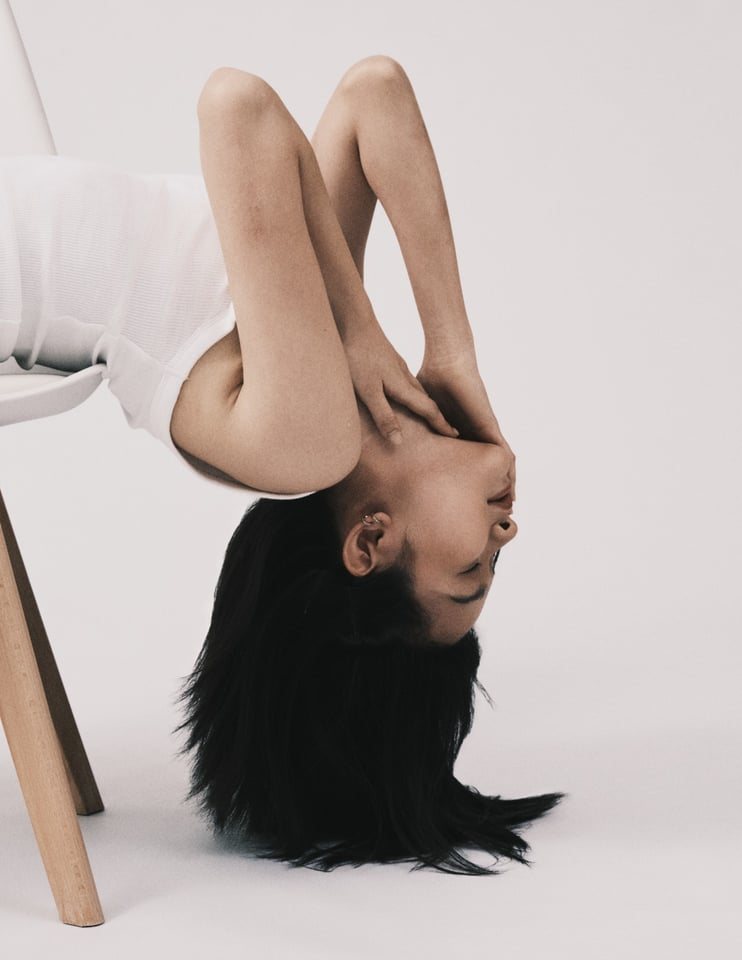 Bent backwards over a chair