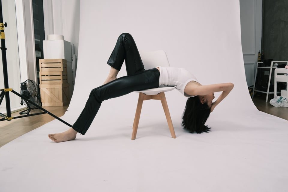 Backbend over a chair, wide studio view