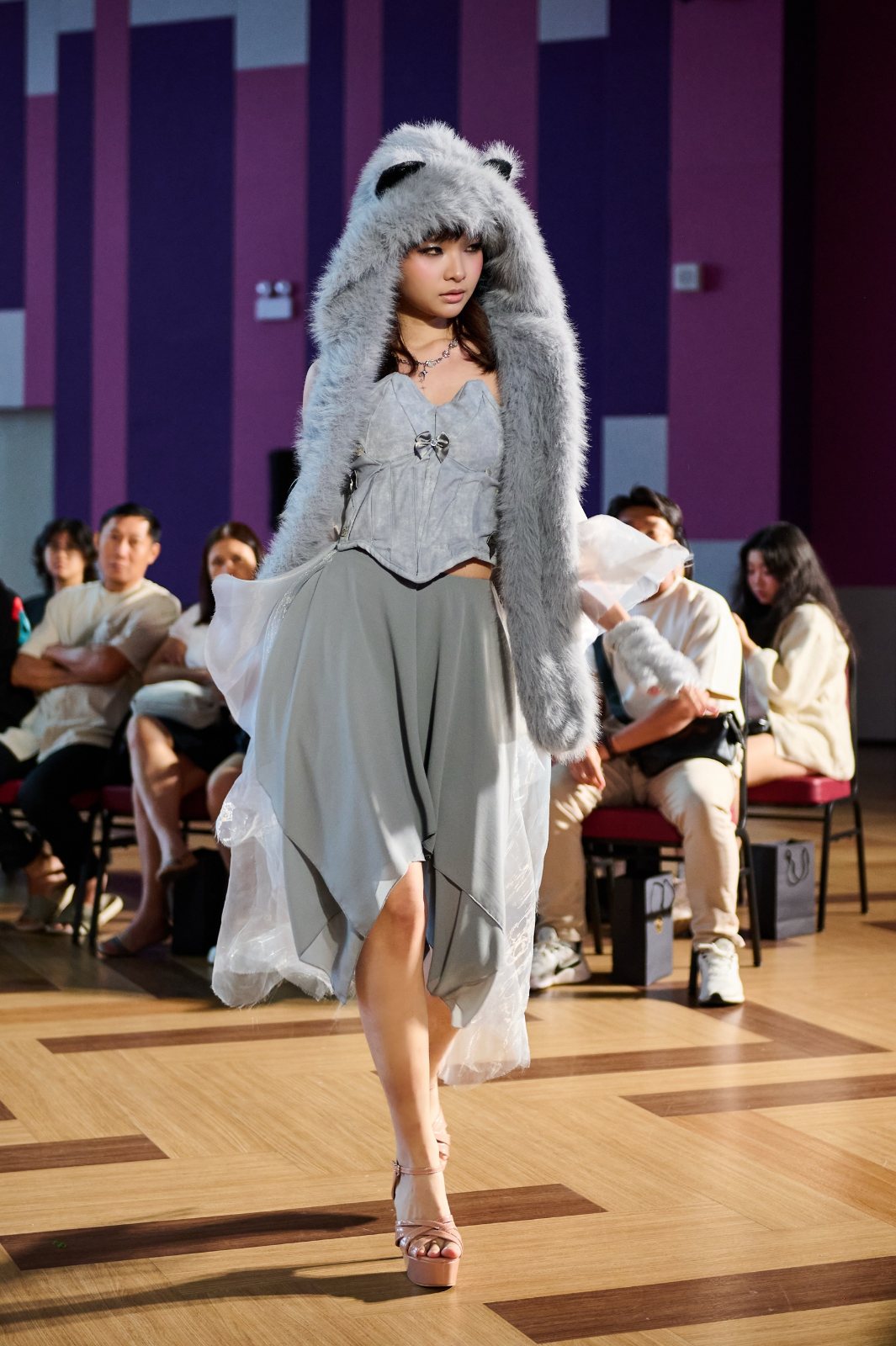 Runway walk in grey faux-fur hood and corset