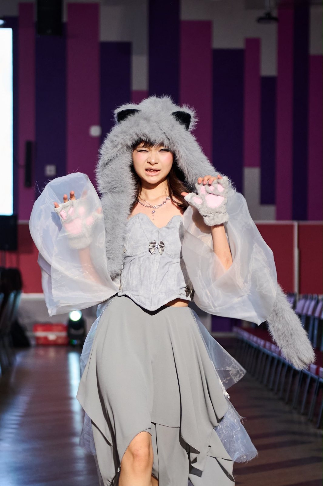 Playful cat-paw pose on the runway
