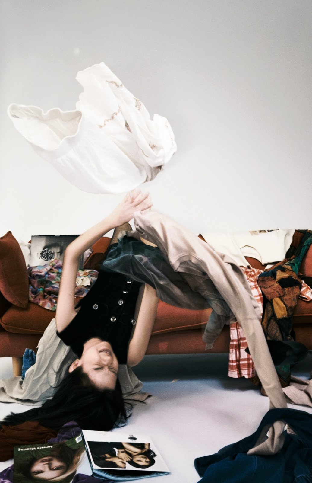 Upside down off the sofa, tossing a white blouse