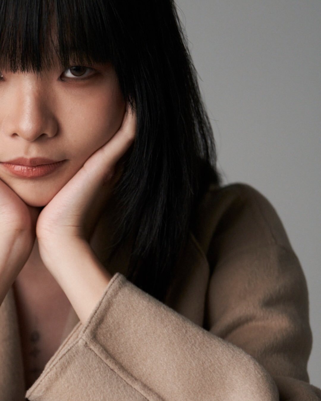 Studio portrait, camel coat, half-face close-up