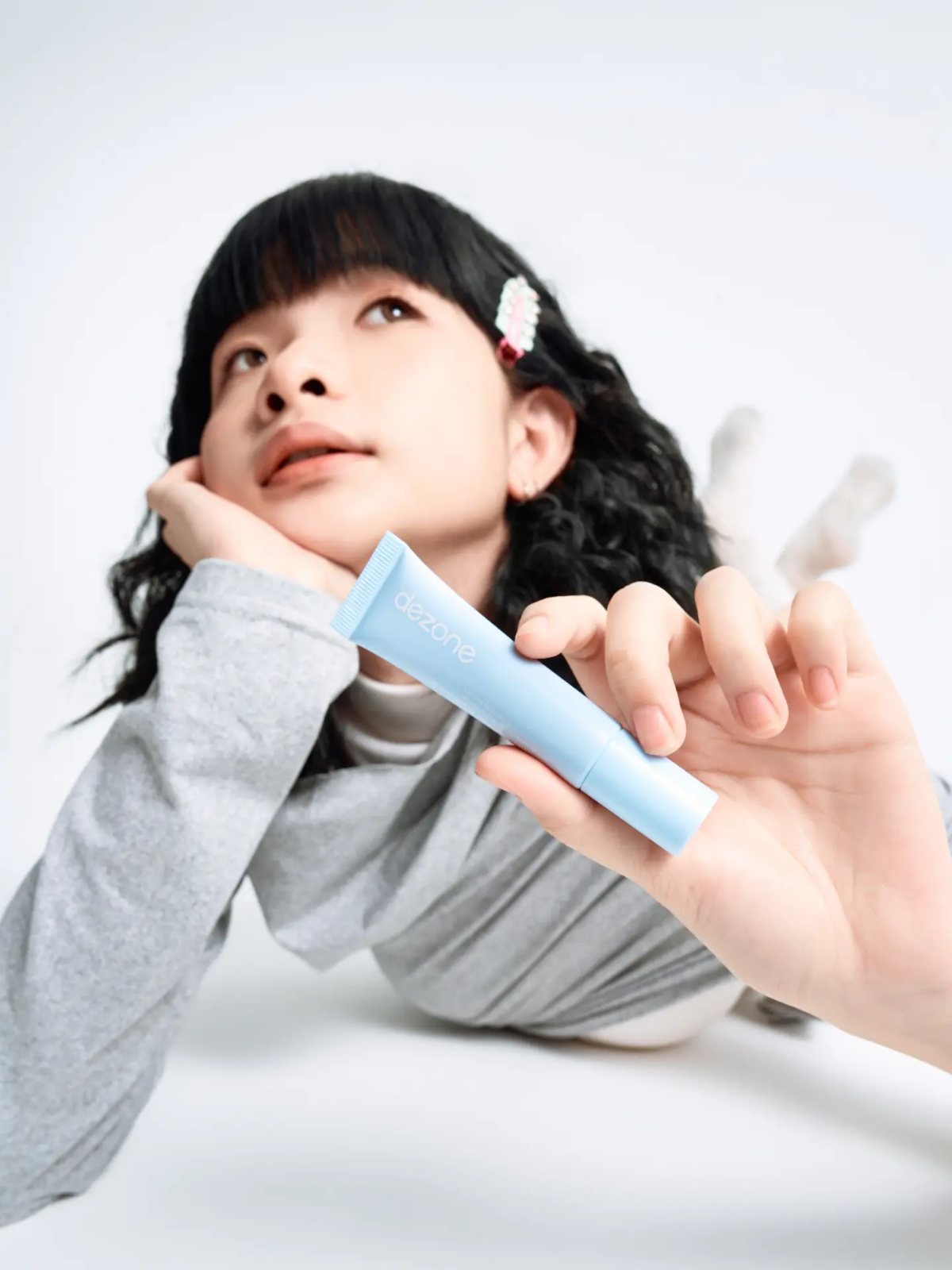 Lipstick campaign, lying down holding tube
